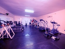 A gym with treadmills, elliptical machines, and weightlifting equipment.