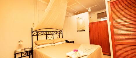 A bedroom with a bed, bedside table, and a wardrobe.