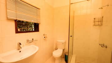 A bathroom with a sink, toilet, and glass-enclosed shower.