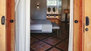 A wooden door leading to a bedroom with a bed, a bedside table, and a lamp. - Can Arabi Adults Only (Santa Eulalia del Rio)