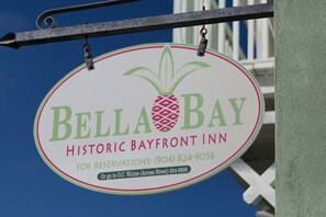 Placa do Bella Bay Historic Bayfront Inn com logotipo de abacaxi, indicando um tema tropical.