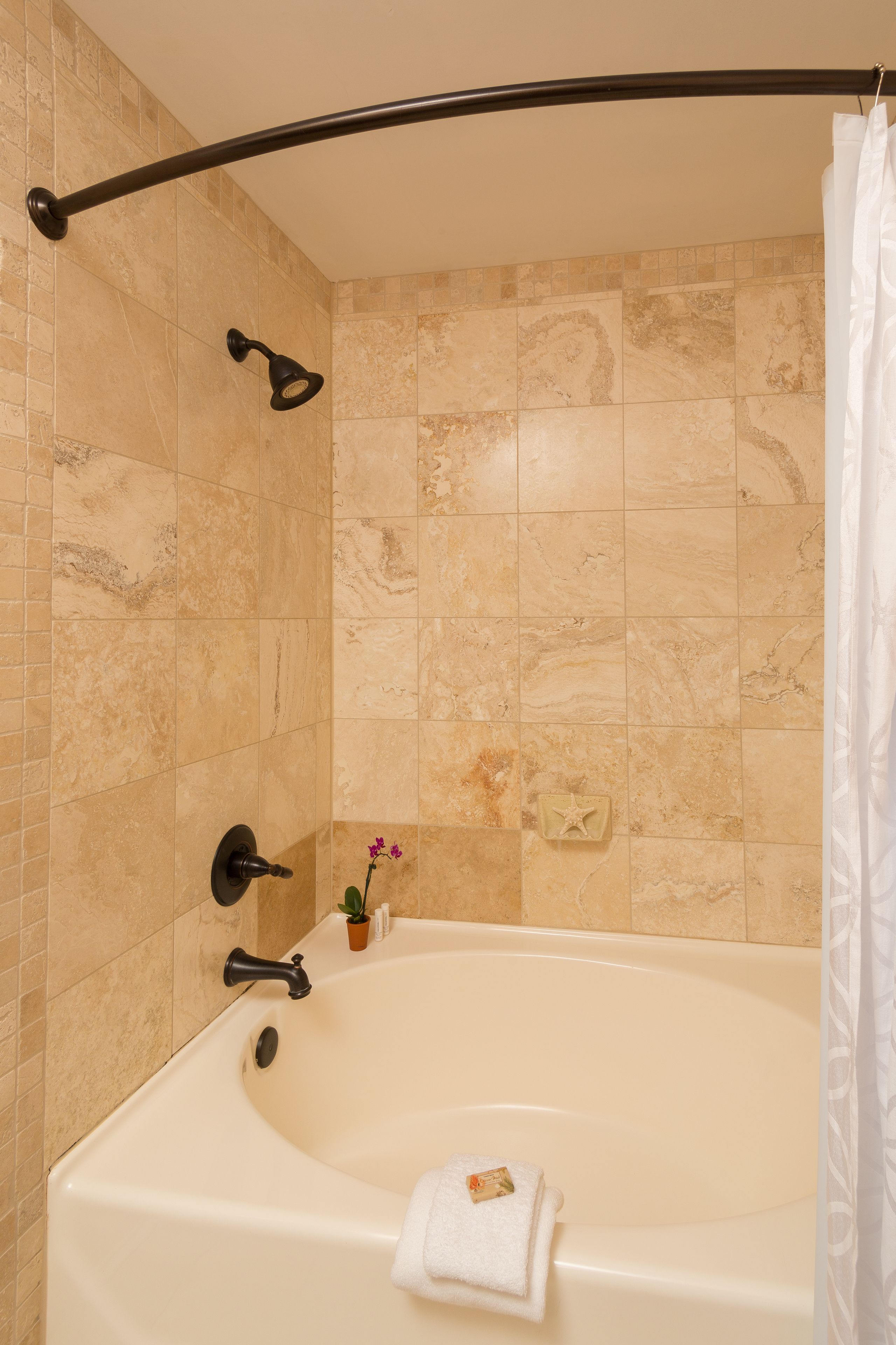 Ein Badezimmer mit einer Badewanne, einer Duschbrause und einem Handtuchhalter.