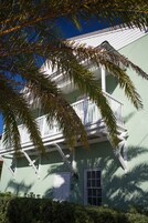 A two-story building with a balcony, a white door, and a window.