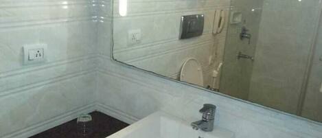 A bathroom with a white sink, a large mirror, and a glass shower enclosure.