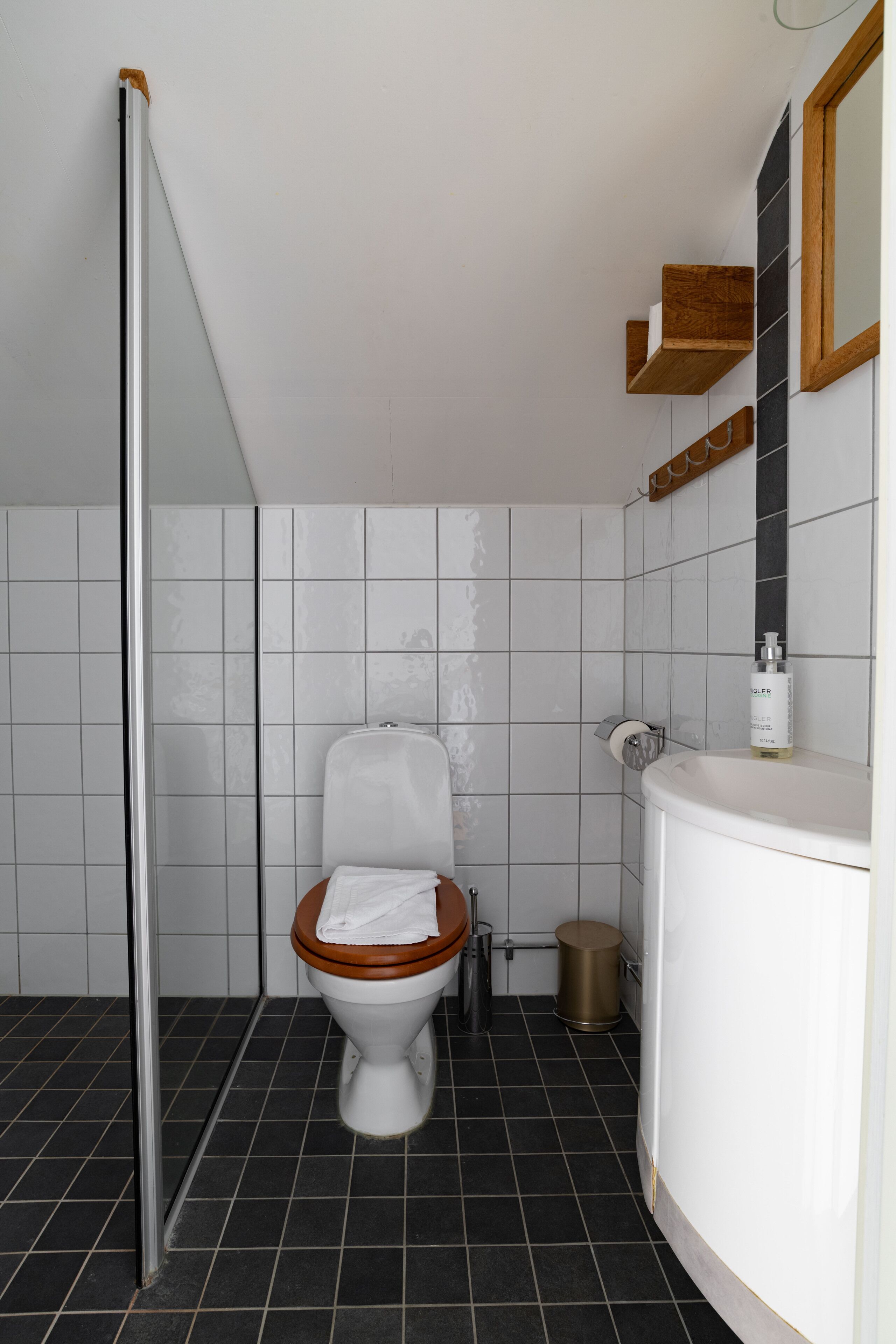 A modern bathroom with a toilet, a shower, and a sink.