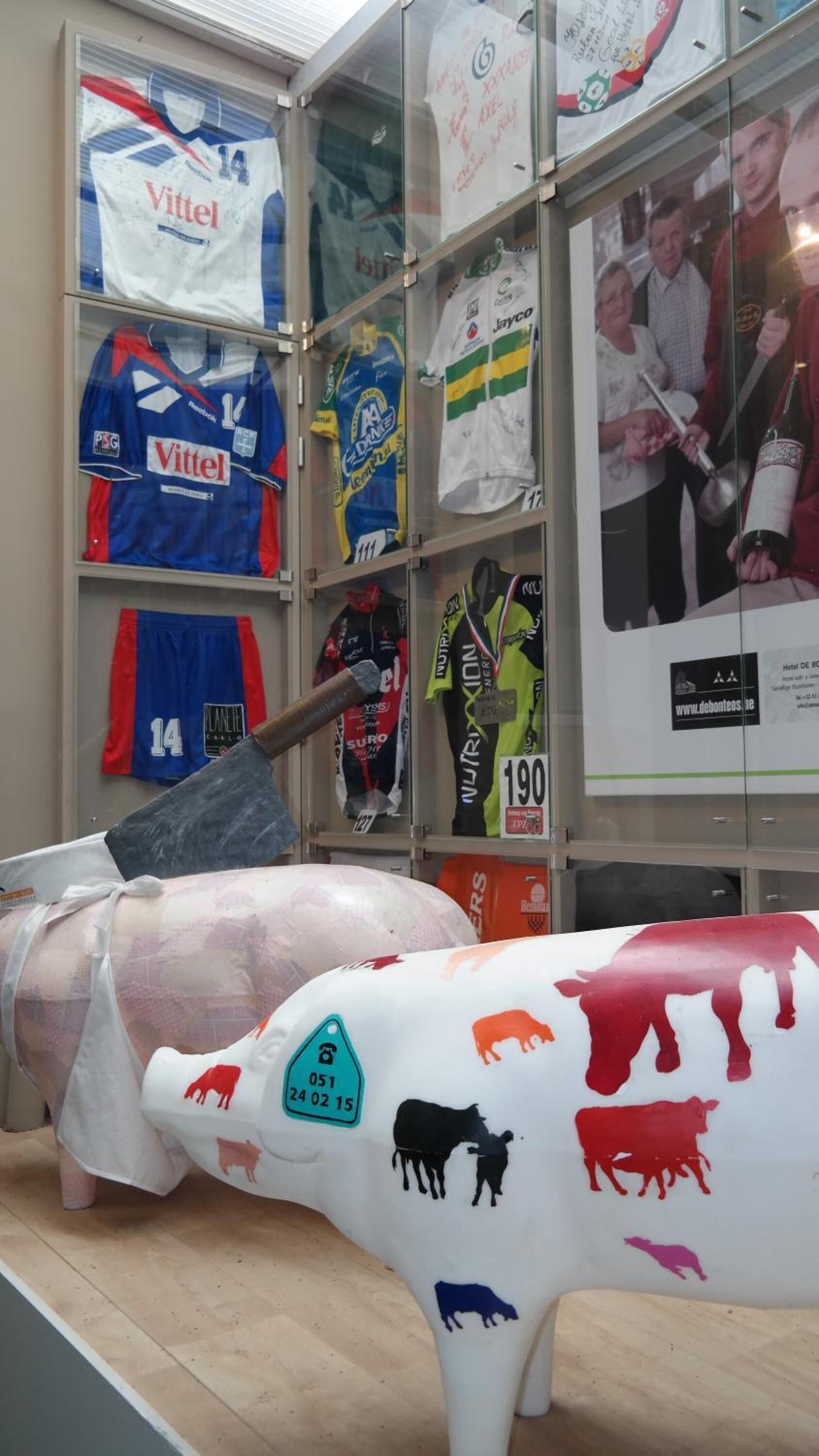 A display of sports jerseys and a large cow sculpture with various animal silhouettes.