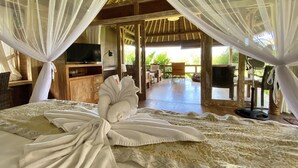 Une chambre à coucher avec un lit, une télévision, une armoire en bois et une vue sur l’extérieur.