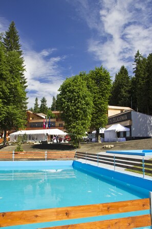 Una piscina al aire libre de temporada, tumbonas