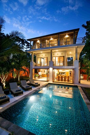 A two-story house with a swimming pool, lounge chairs, and a dining area. - Casa Mimba (Padangbai)