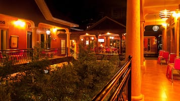 A hotel lobby with a central atrium, columns, and red seating areas.