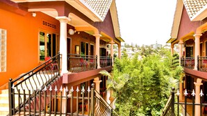 A hotel with multiple balconies, a central courtyard with greenery, and a view of the surrounding buildings. - Cari Hotel (Kigali)