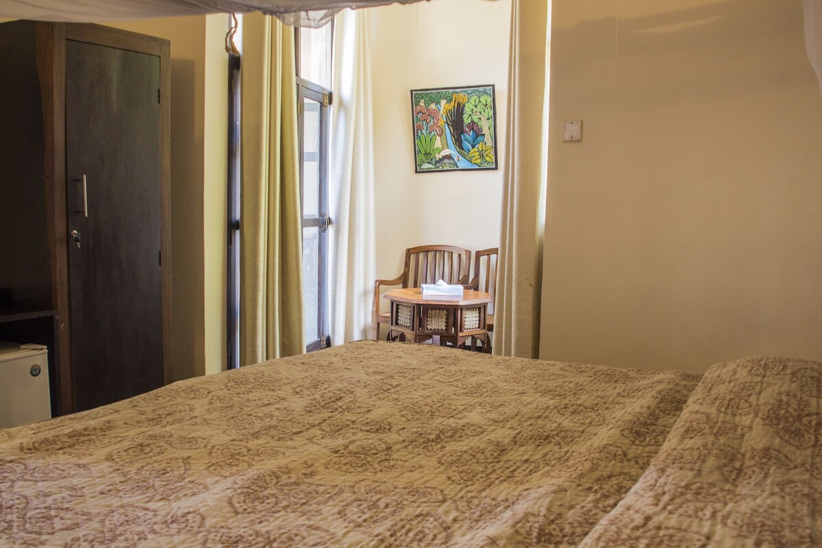 Une pièce comprenant un lit, une chaise, un bureau et une armoire.