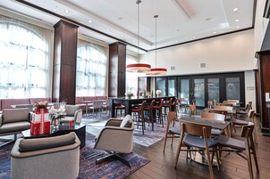 Un hall de hotel con zonas de estar, un bar y un área para desayunos.