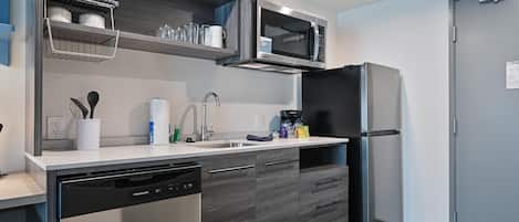 A modern kitchen with a dishwasher, a microwave, and a refrigerator.