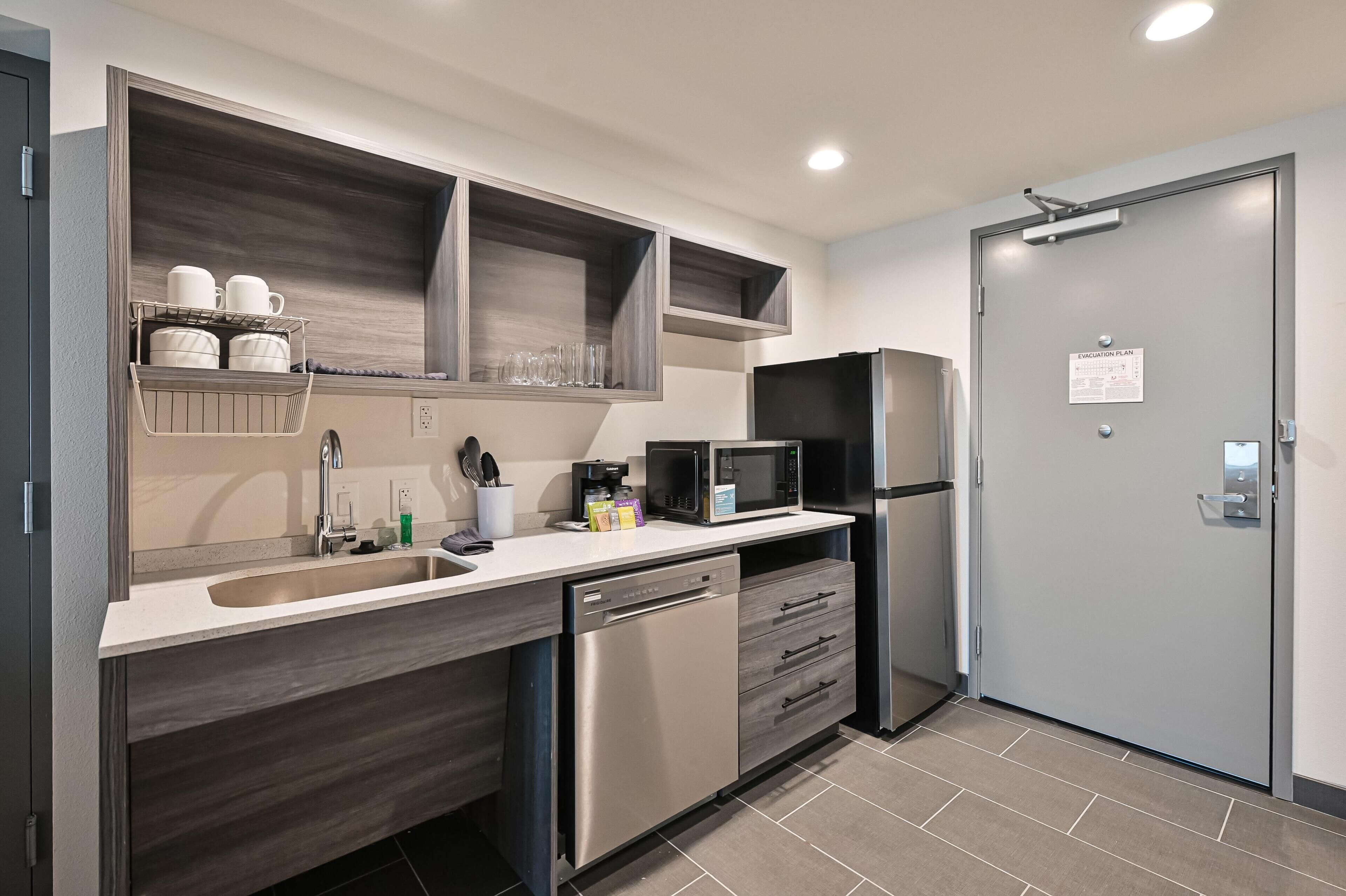 Una cocina moderna con electrodomésticos integrados, lavavajillas y refrigerador.
