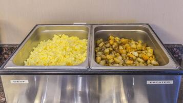 Un bufé de acero inoxidable con compartimentos etiquetados para 'OEUF' y 'PATATES'.