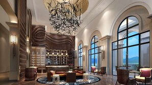 A spacious lobby with a large chandelier, arched windows, and a central seating area. - Hilton Yuxi Fuxian Lake (Yuxi)