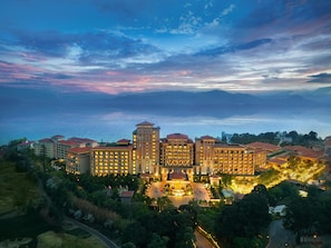 A hotel complex with multiple buildings, a central courtyard, and a view of the sea.
