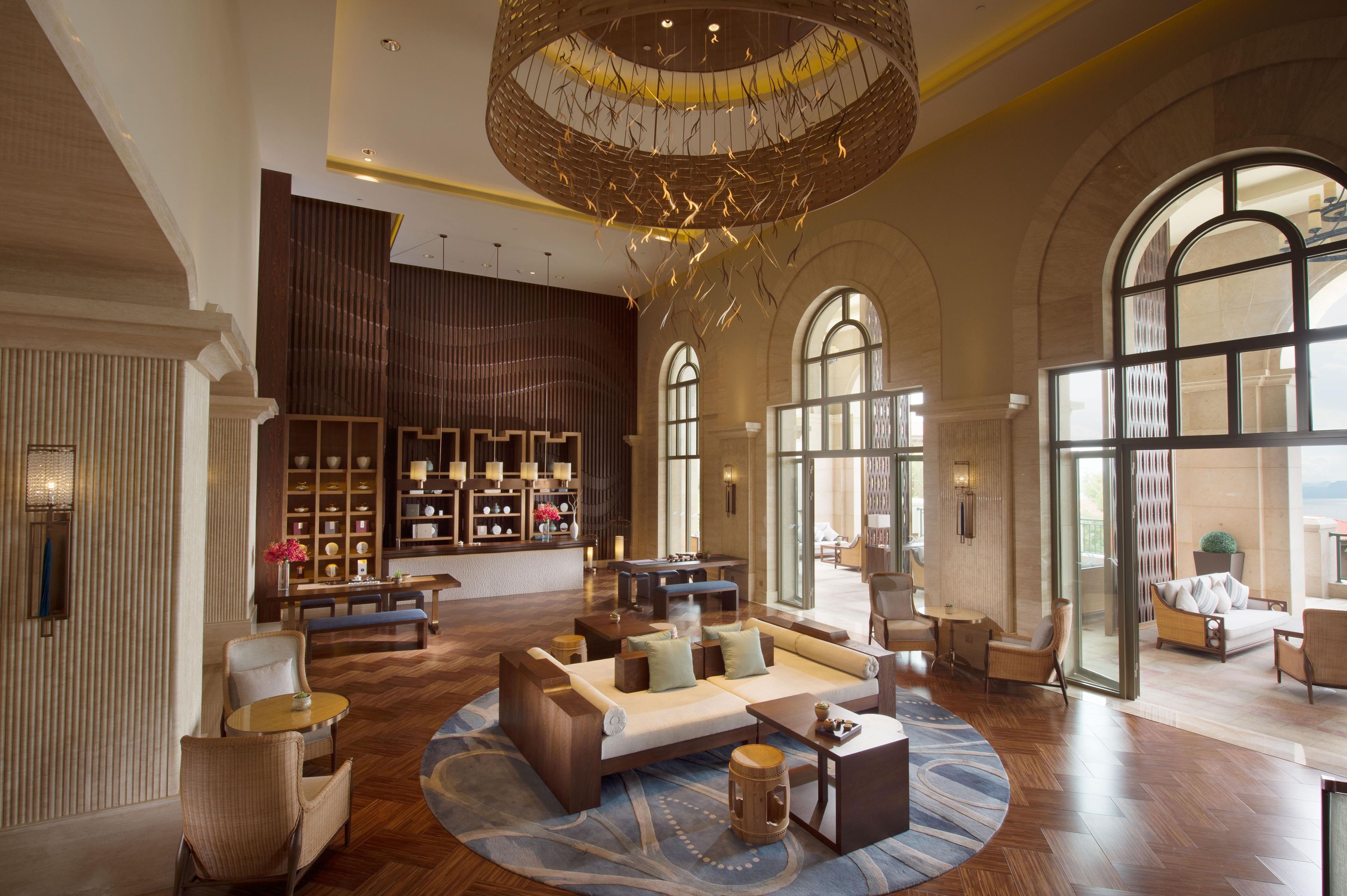 A spacious lobby with a high ceiling, a central seating area, and a wall of decorative shelves.
