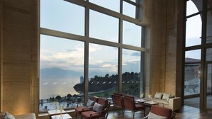 A spacious living room with large arched windows, a sofa set, and a coffee table. - Hilton Yuxi Fuxian Lake (Yuxi)
