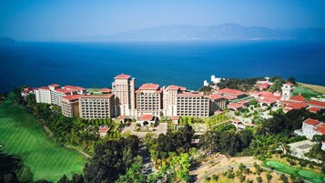 Un gran hotel con varias edificaciones, una torre central y un campo de golf.