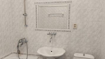 Een badkamer met een wit wastafel, douche en toilet.