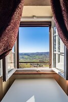 A room with a large window overlooking a scenic landscape.