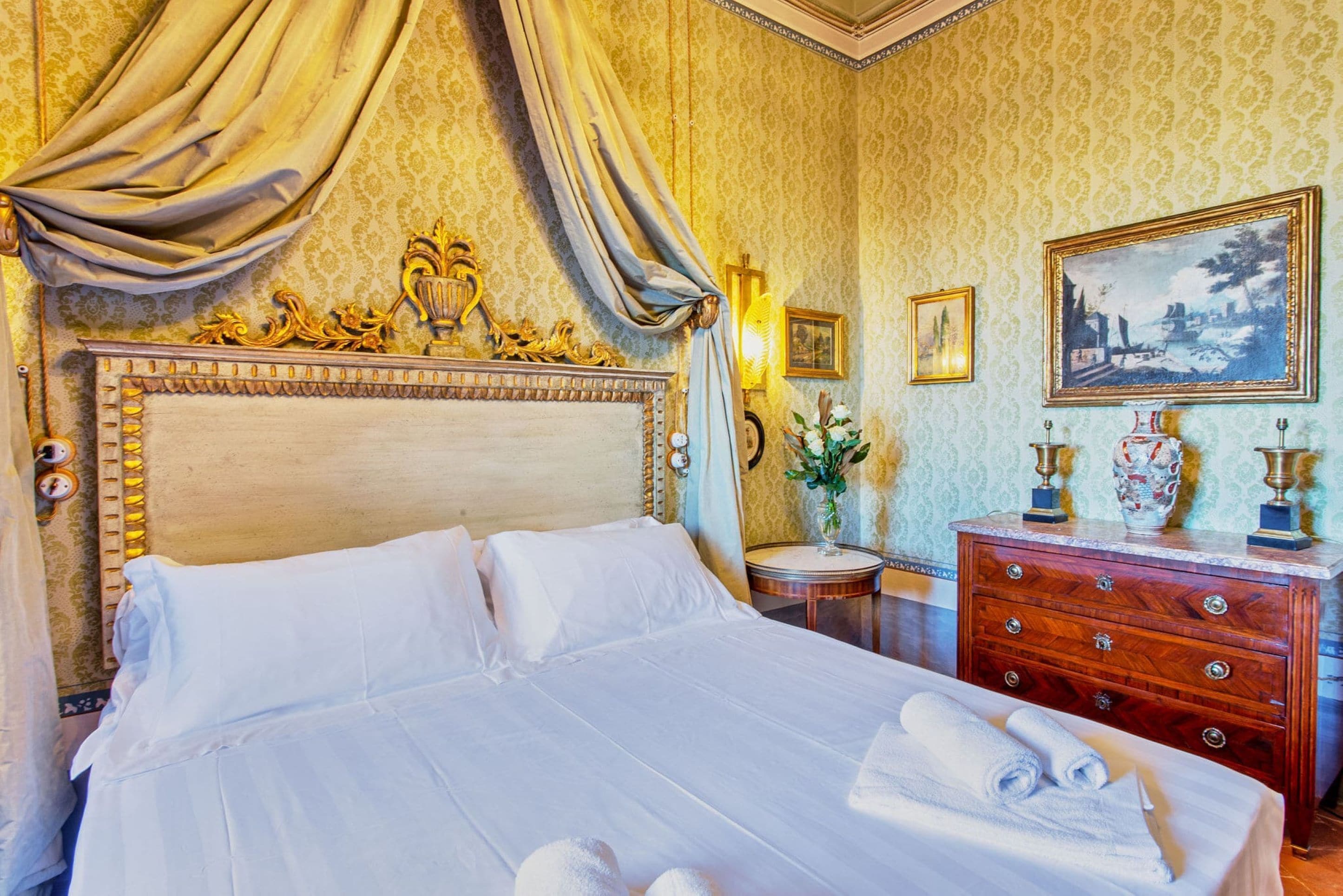 Une chambre d’hôtel avec un grand lit, une commode en bois et un tableau accroché au mur.