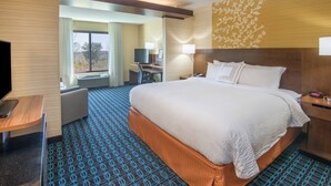 A hotel room with a large bed, a desk with a chair, a television, and a window with curtains. - Fairfield Inn & Suites Fort Wayne Southwest (Fort Wayne)