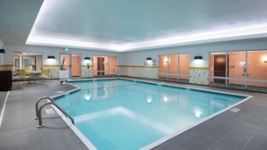 An indoor swimming pool with clear water, surrounded by tiled walls and doors leading to other rooms. - Fairfield Inn & Suites Fort Wayne Southwest (Fort Wayne)