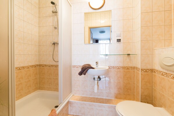 A bathroom with a bathtub, a sink, and a toilet. - Aparthouse Apartamenty (Katowice)