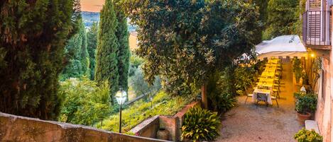 A courtyard with a dining area and a view of the city.