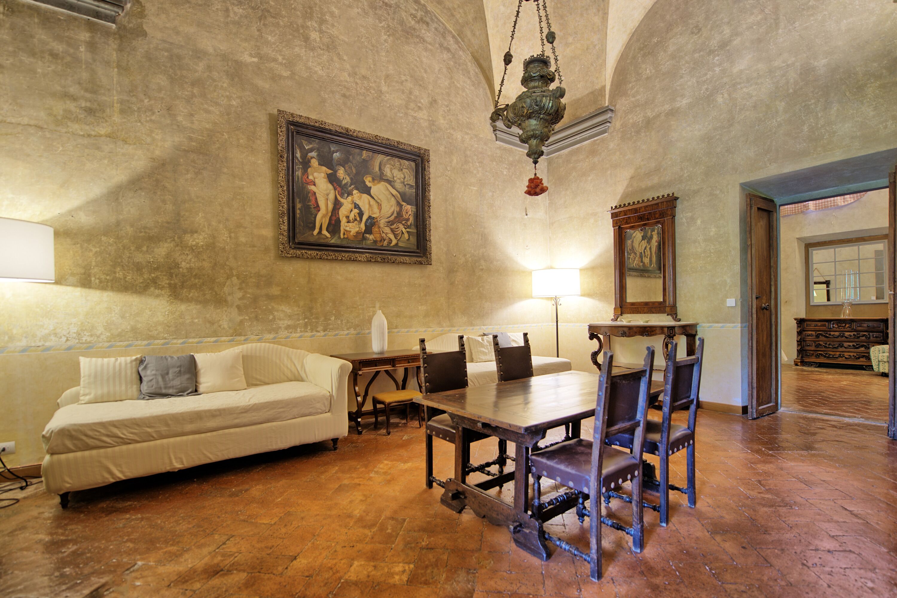 Une pièce comprenant une table à manger, des chaises, un canapé et un tableau accroché au mur.