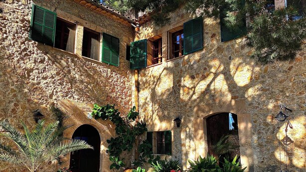 A courtyard with stone walls, green shutters, and potted plants. - Asis de Marratxinet (Marratxi)