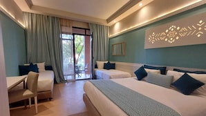 Habitación de hotel con dos camas, un escritorio y una silla. Hay una puerta corrediza de vidrio que da a un espacio exterior.