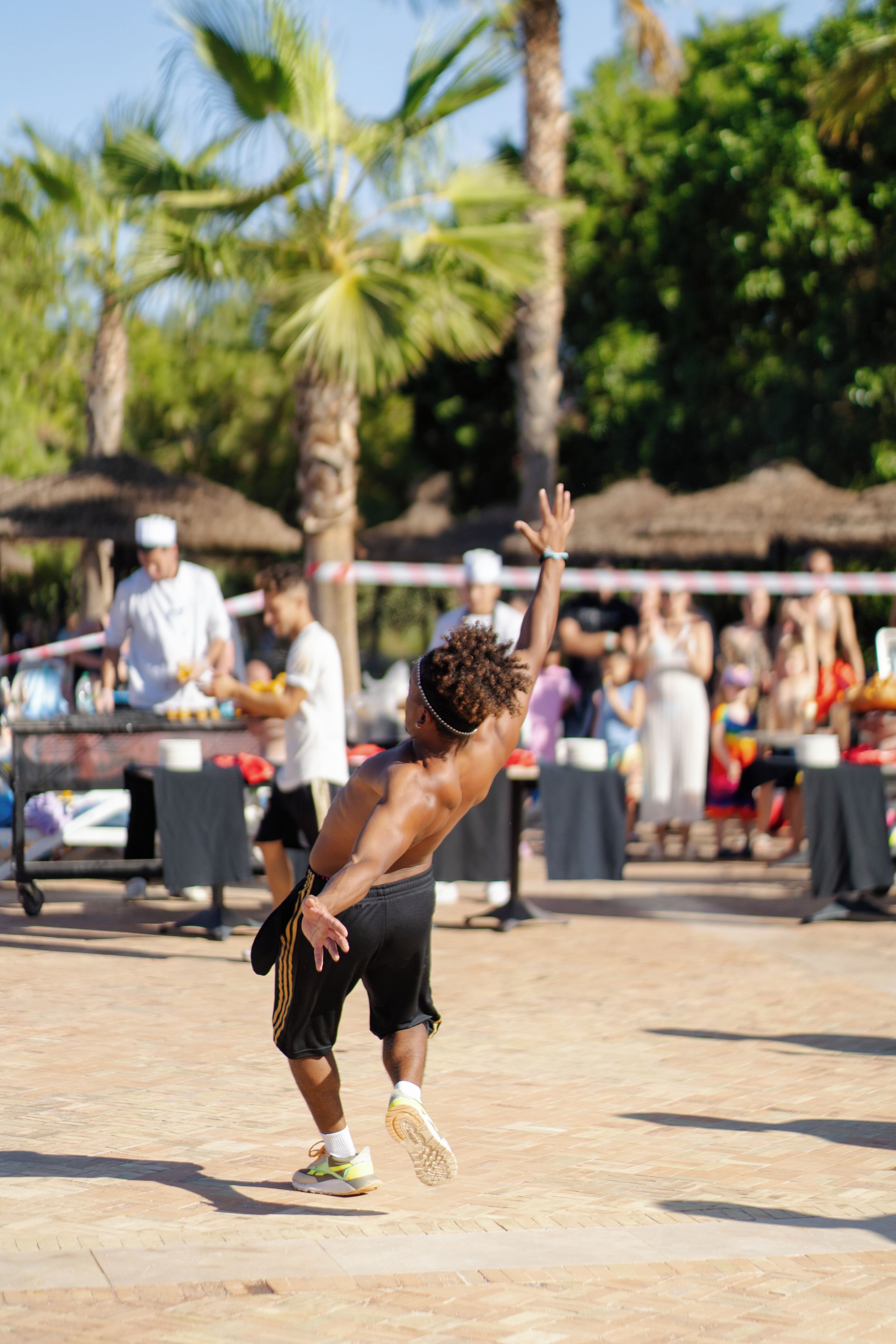 A person playing a sport outdoors with a crowd in the background.