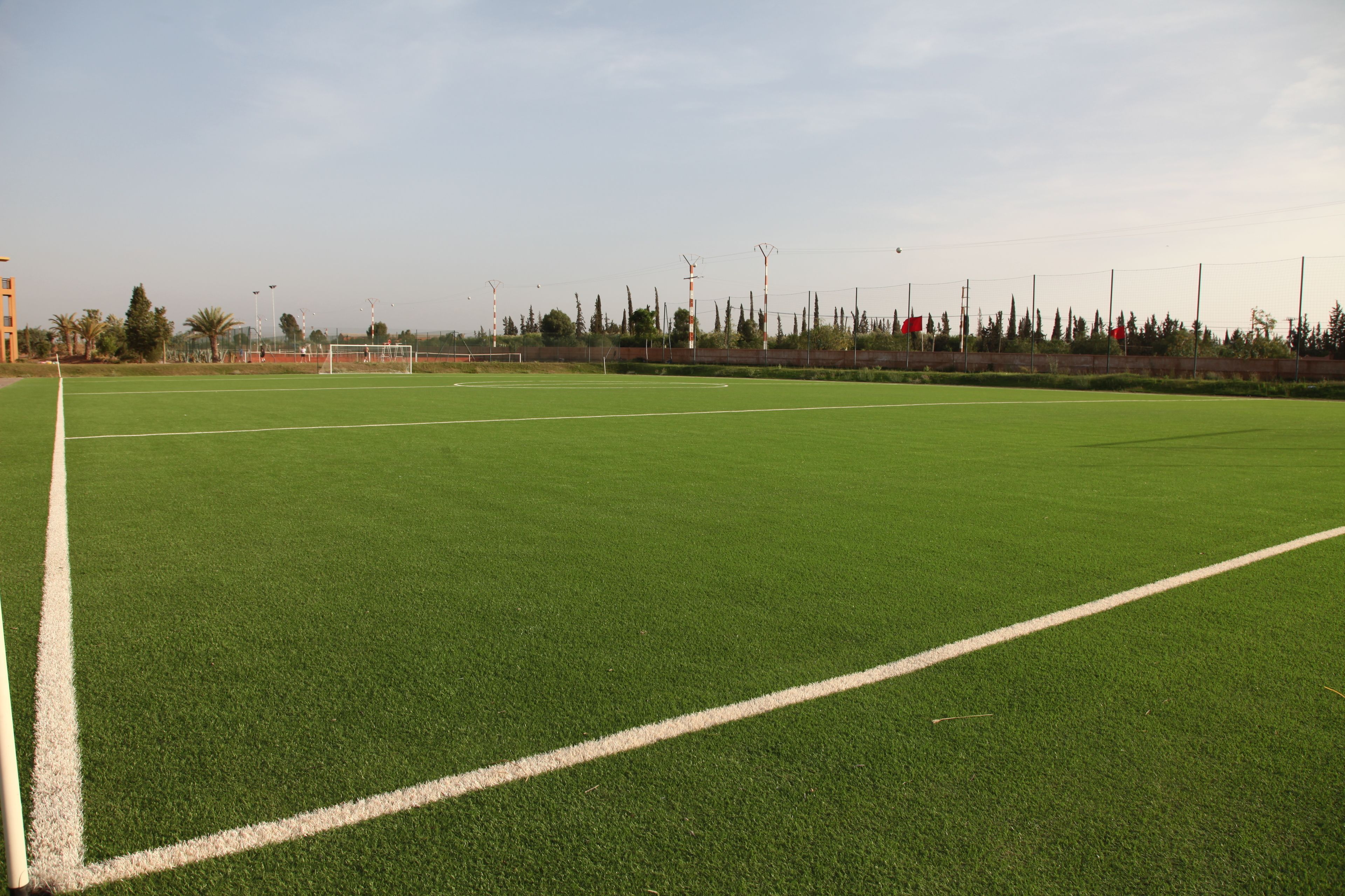 A large, open field with white boundary lines, likely a sports field.