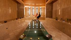 Un área de spa con una piscina central, bancos y velas.