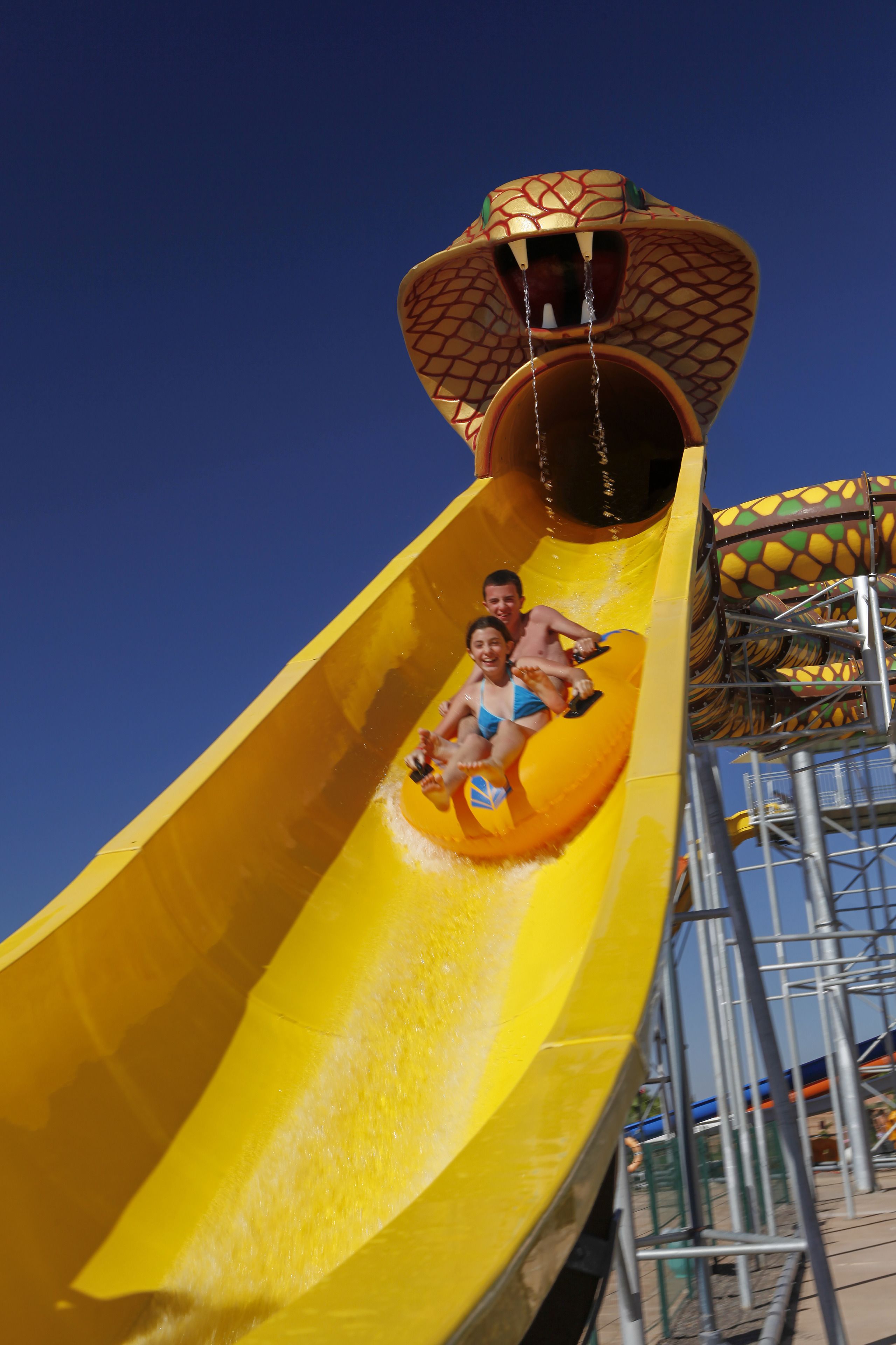A water slide with a curved design and a platform at the top.