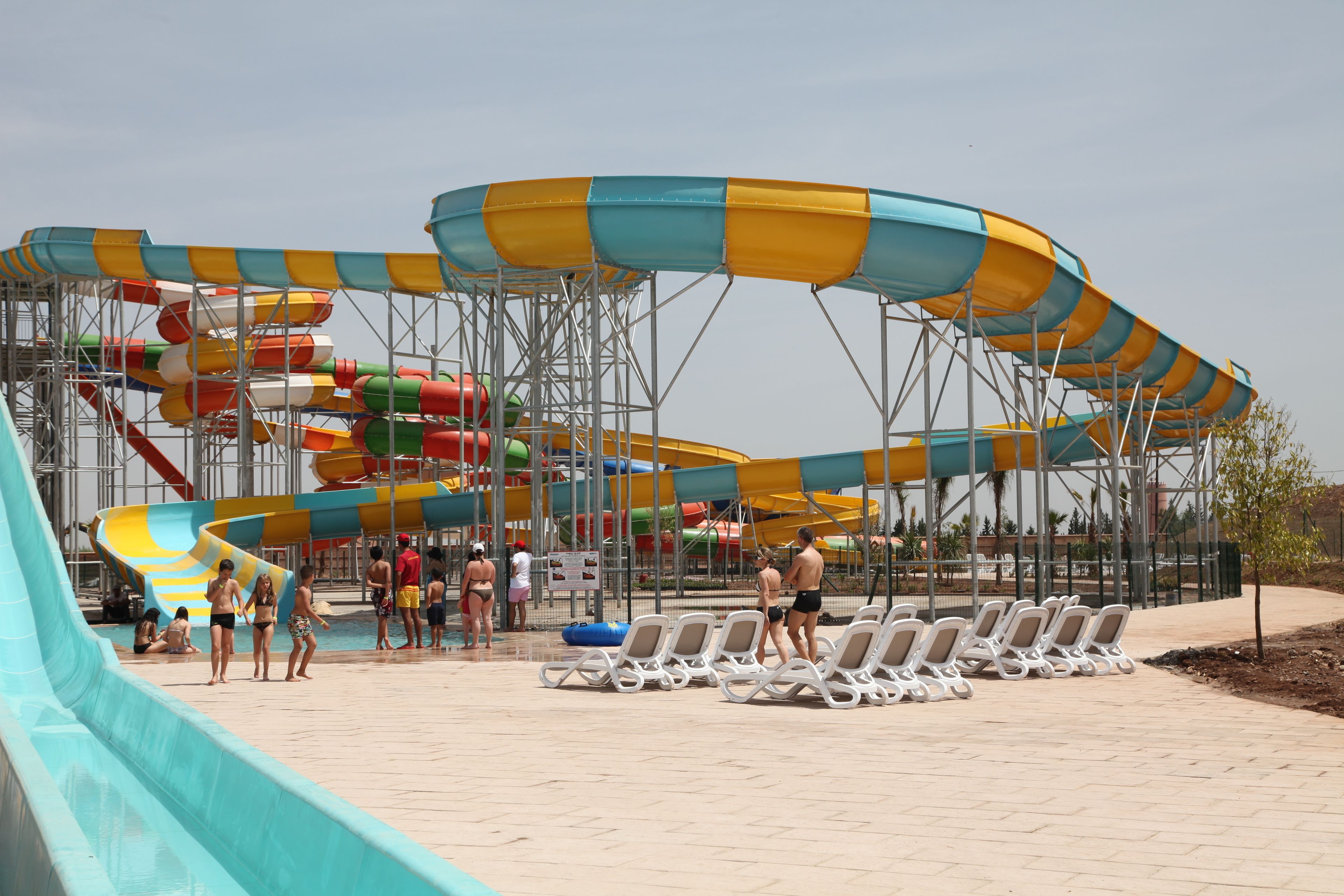 Un parc aquatique doté de nombreuses toboggans et de chaises longues.