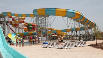 Un parc aquatique doté de nombreuses toboggans et de chaises longues.