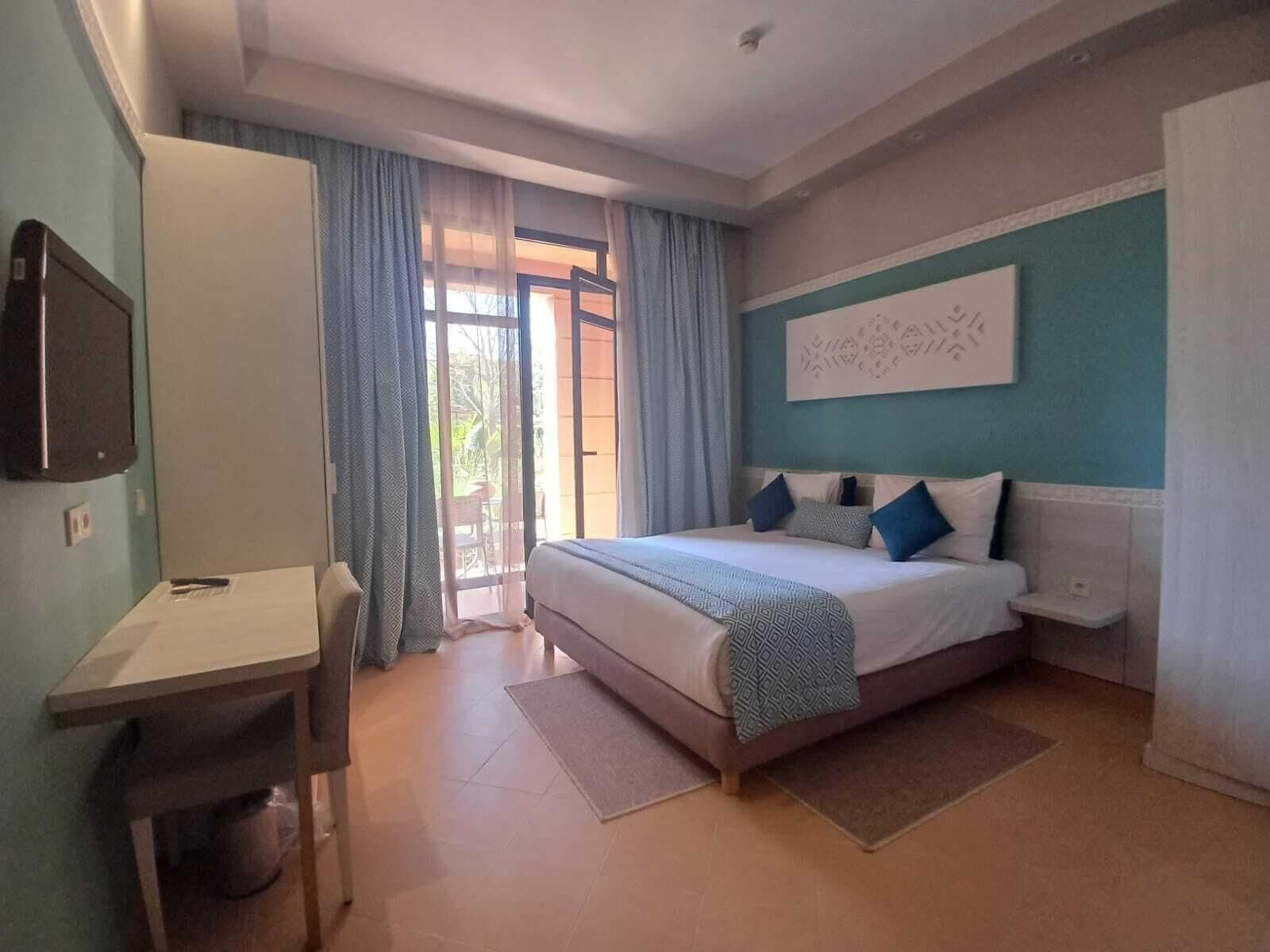 Una camera da letto con un letto, una scrivania e una televisione.