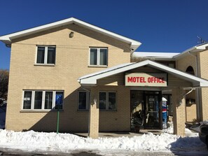 A two-story motel with a sign reading "Motel Office" and a wheelchair accessibility sign.