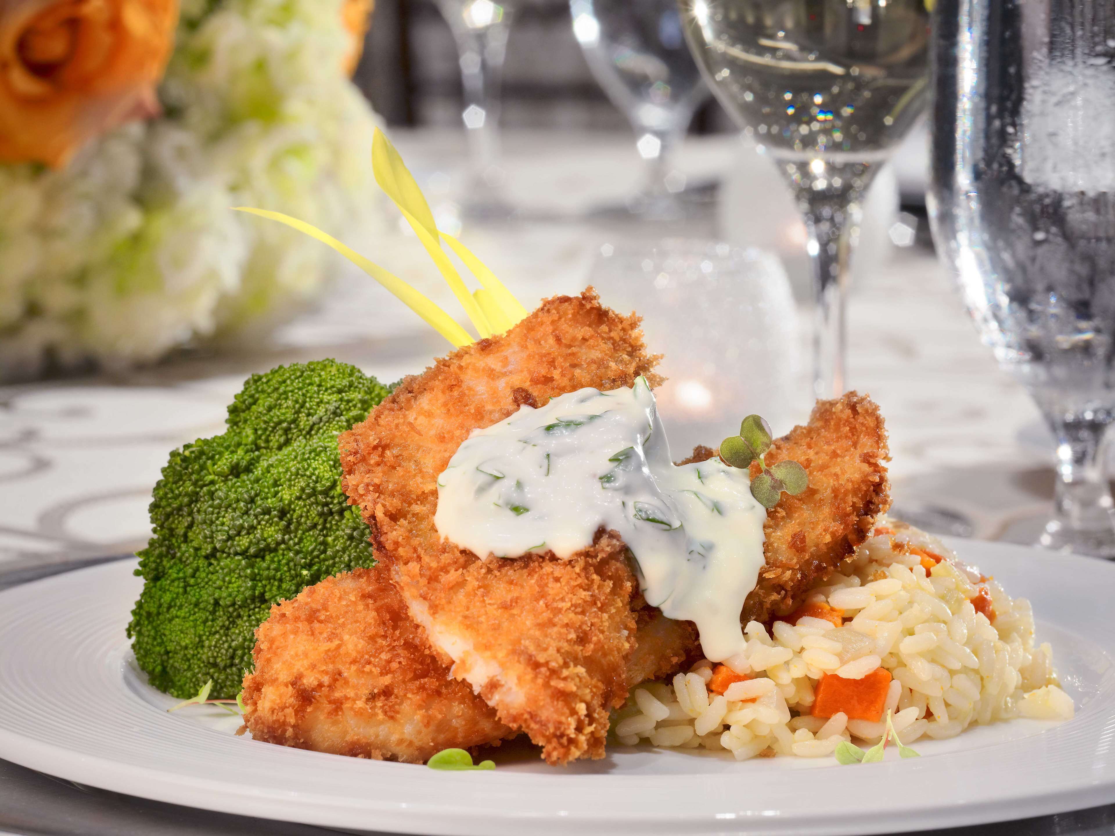 A plate with breaded chicken, broccoli, and rice.
