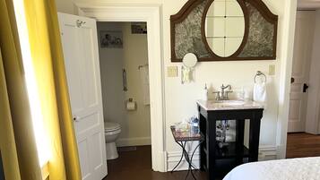 A hotel bathroom with a toilet, sink, and mirror.