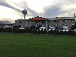 A Royal Inn building with a parking lot and a water tower in the background.