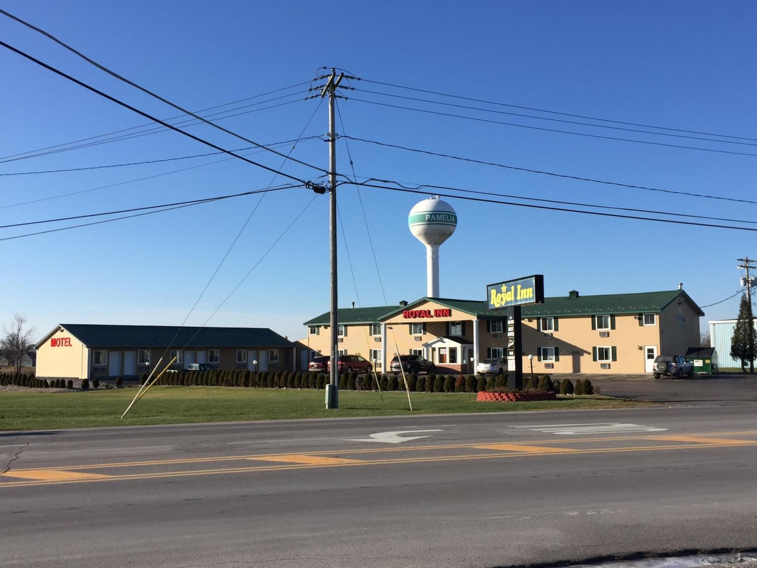 A motel with a water tower, a sign for the Royal Inn, and a motel sign.