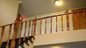 A staircase with wooden handrails leading to an upper floor. - Royal Inn Motel (Watertown)
