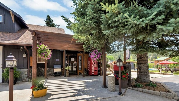 A building with a wooden entrance, a Coca-Cola vending machine, and a sign that says "Welcome". - Lantern Inn (Hill City)