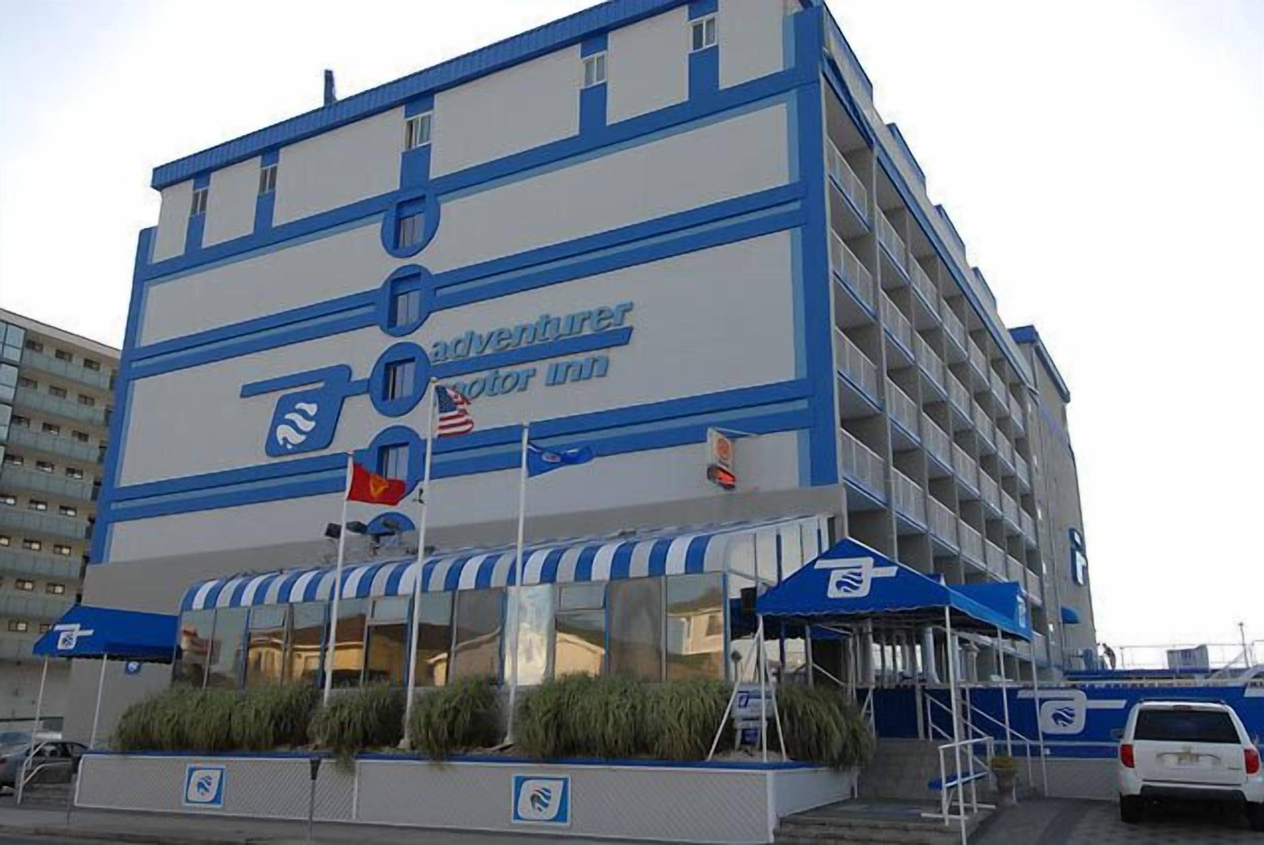 A multi-story building with a blue and white color scheme, featuring a sign for 'adventurer motor inn'.